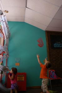 My son catching a scarf from the top of the vacuum tubes.